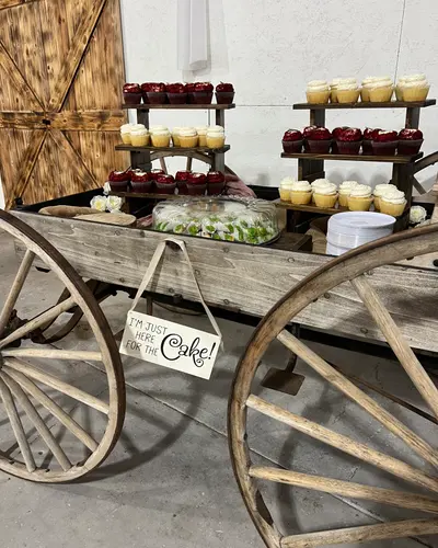 A vintage bicycle and wagon wheel decorated with flowers and a welcome sign