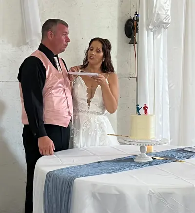 The bride and groom cutting their wedding cake at the candlelit head table