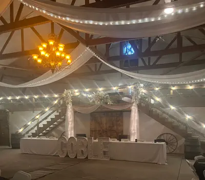 The barn interior glowing with warm string lights in the evening