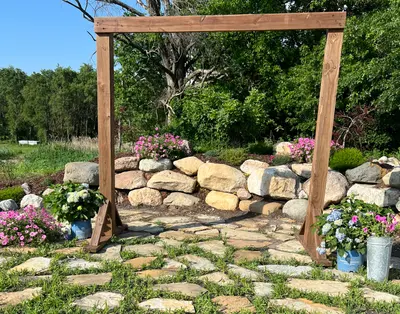 A wooden pergola and stone pathway in the garden at golden hour