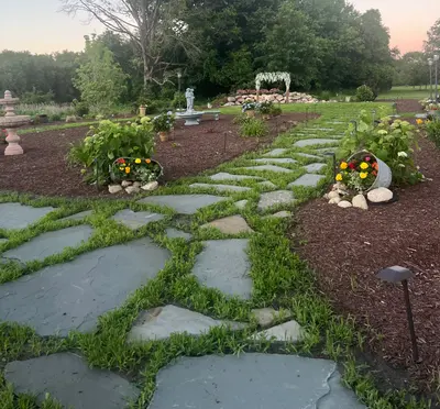 Stone pathways threading through the garden's flower beds, with the ceremony lawn beyond