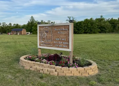 The DnB Barn engraved welcome sign set in a stone flower bed at the entrance